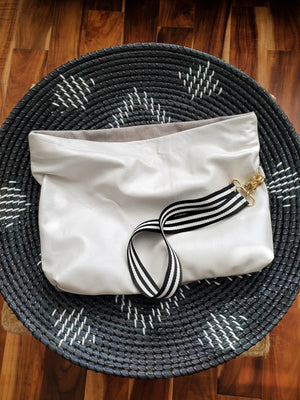 First to the 50 Shades of Color + Grey is this icy pearlized white lambskin leather paired with a velvet textured fabric.  You like your options right?  This clutch comes with removable straps for versatility.  Folder over as a clutch or wear it across your shoulders  Dimensions (straight and unfolded):  17" L x 12" W 100 % lambskin leather Cotton lining Inside pocket Magnetic closure