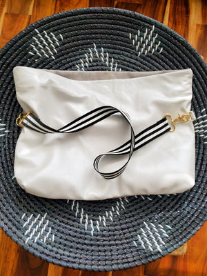 First to the 50 Shades of Color + Grey is this icy pearlized white lambskin leather paired with a velvet textured fabric.  You like your options right?  This clutch comes with removable straps for versatility.  Folder over as a clutch or wear it across your shoulders  Dimensions (straight and unfolded):  17" L x 12" W 100 % lambskin leather Cotton lining Inside pocket Magnetic closure